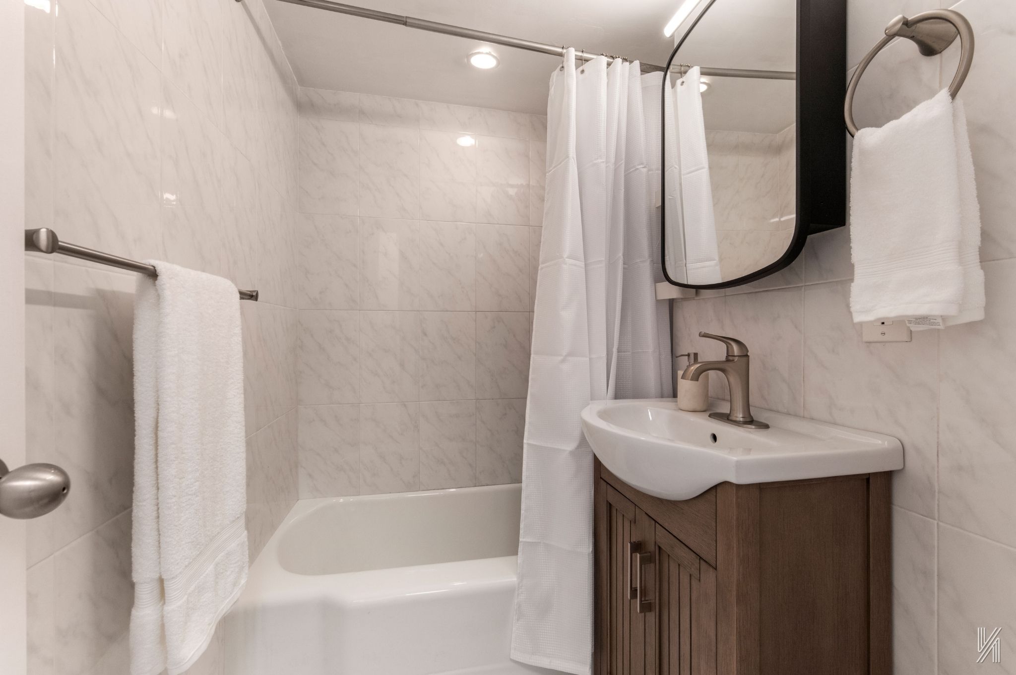 35-50 85th Street, Unit 7H Queens, NY 11372 - Photo 12 of 16 a bathroom with a sink vanity tub and a mirror