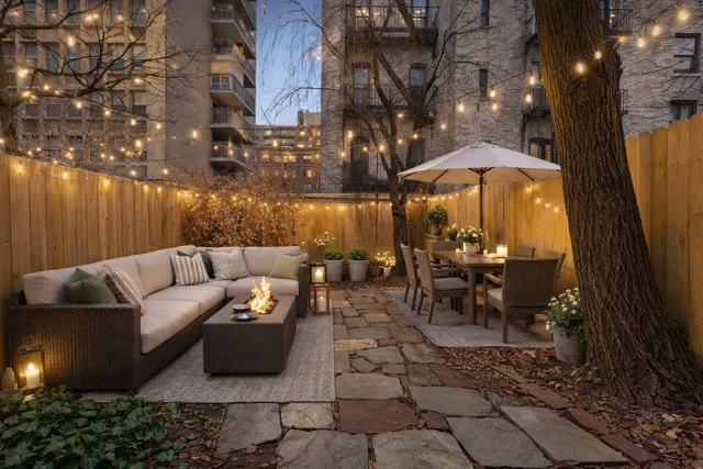 a view of a patio with couches table and chairs under an umbrella with a fire pit