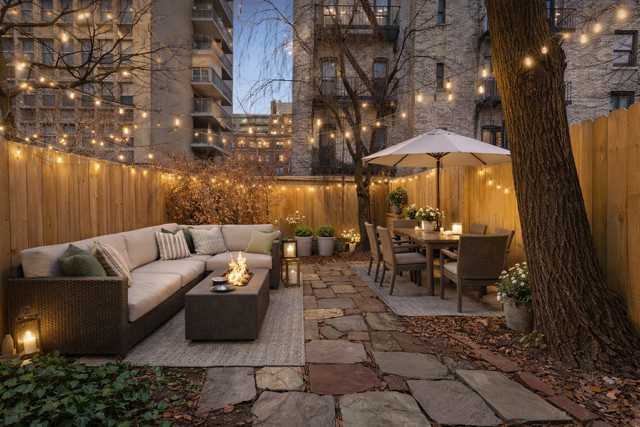 127 West 95th Street Manhattan, NY 10025 - Photo 12 of 15 a view of a patio with couches table and chairs under an umbrella with a fire pit
