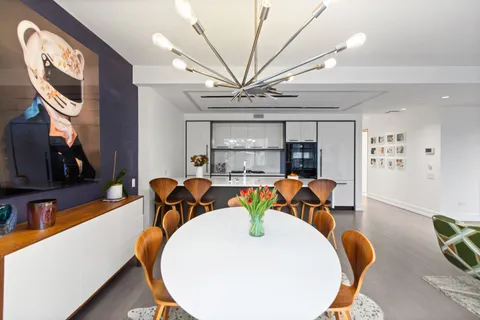 a living room with furniture a chandelier and a wooden floor
