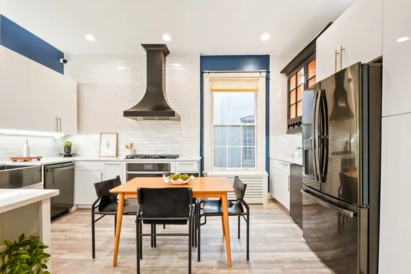 a kitchen with stainless steel appliances granite countertop a stove refrigerator and a view of living room