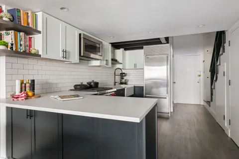 a kitchen with stainless steel appliances a refrigerator sink and cabinets