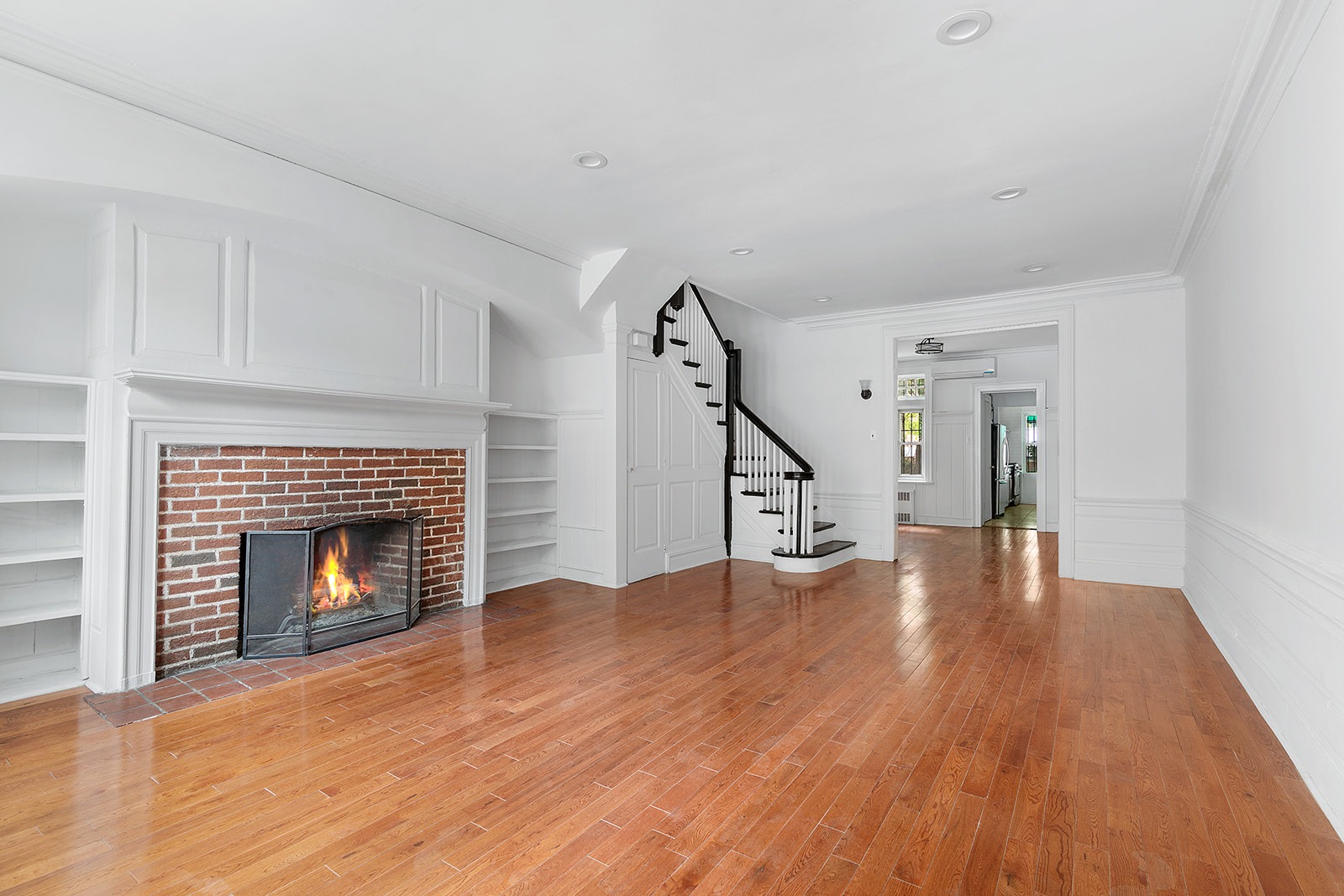 165 Fenimore Street Brooklyn, NY 11225 - Photo 2 of 13 a view of an empty room with wooden floor fireplace and a window