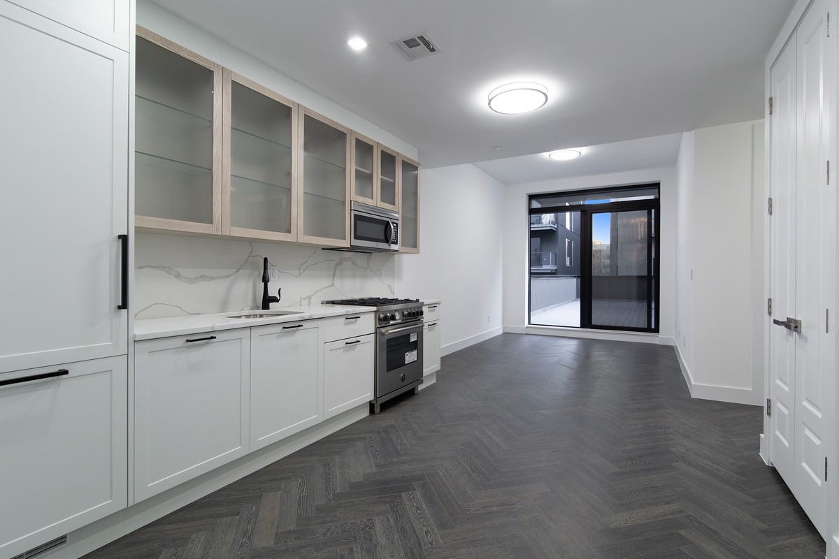 11-12 44th Drive, Unit 2B Queens, NY 11101 - Photo 10 of 15 a view of a kitchen with stainless steel appliances granite countertop a stove and a sink