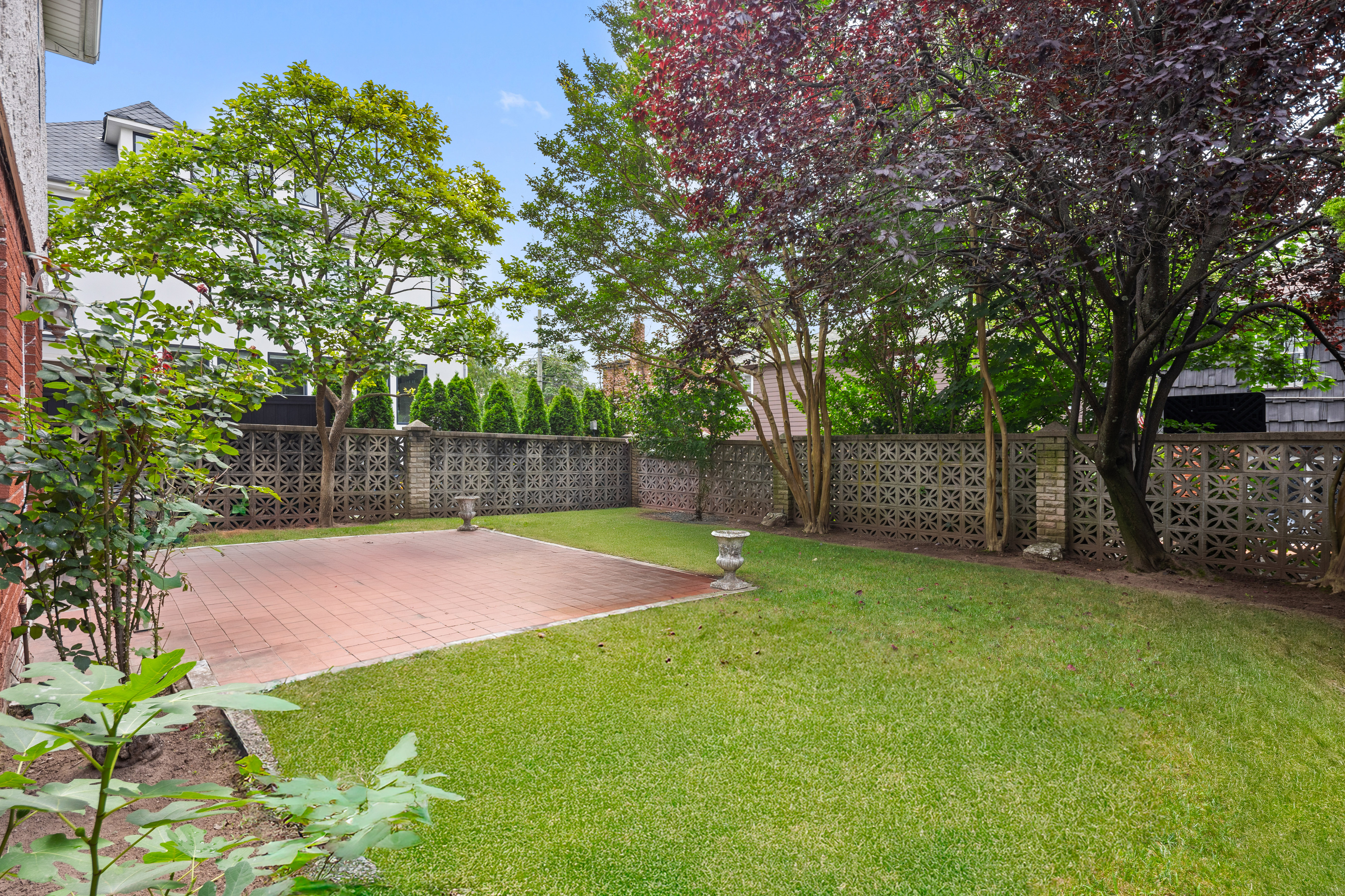 110 82nd Street Brooklyn, NY 11209 - Photo 21 of 28 a view of a backyard with large trees and wooden fence