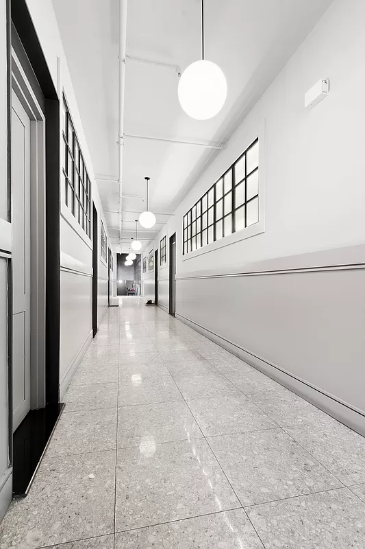 180 Bainbridge Street, Unit 111 Brooklyn, NY 11233 - Photo 20 of 25 a view of staircase with lots of frames on wall and a large window