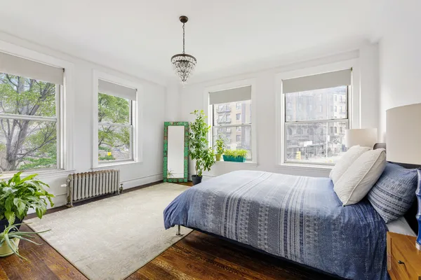 a bedroom with a large bed and windows