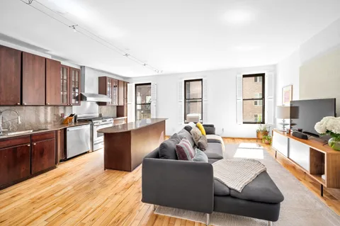 a living room with stainless steel appliances granite countertop furniture and a wooden floors