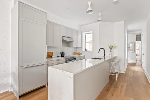 a kitchen with white cabinets and stainless steel appliances