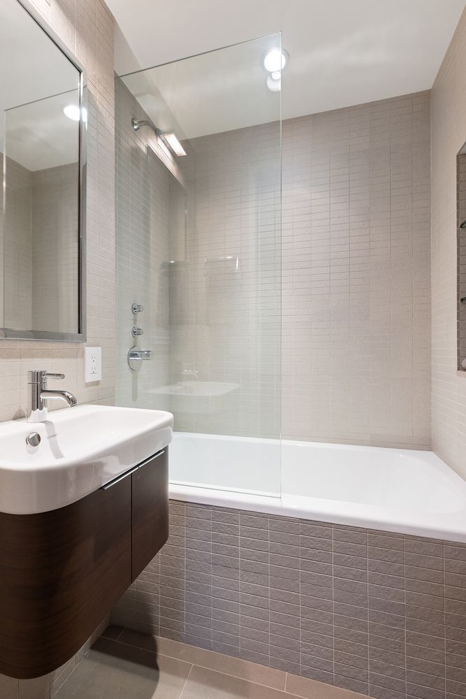 25 Central Park West, Unit 27J Manhattan, NY 10023 - Photo 12 of 13 a bathroom with a bathtub a sink and a mirror