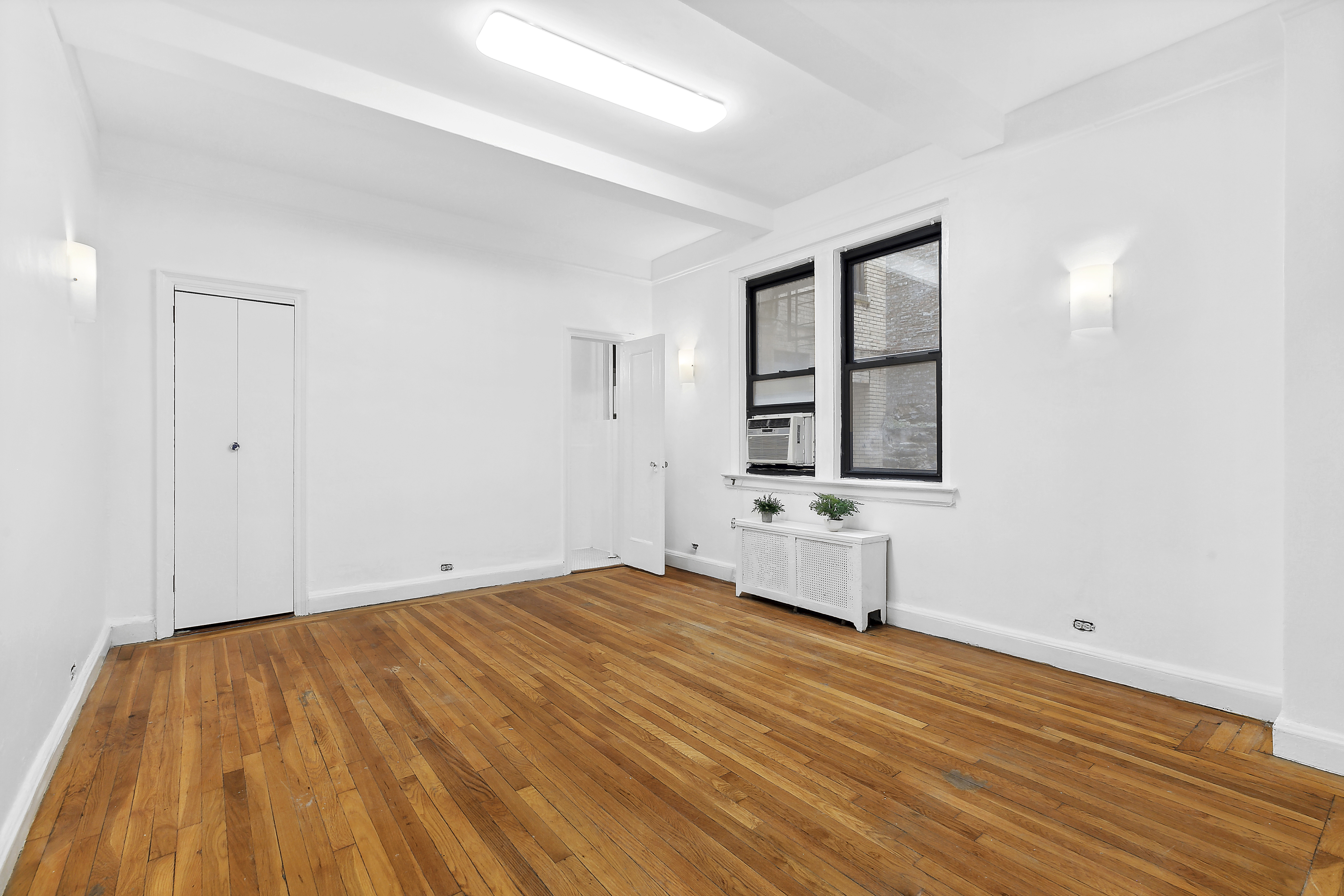 321 East 54th Street, Unit 1D Manhattan, NY 10022 - Photo 2 of 7 a view of an empty room with wooden floor and a window