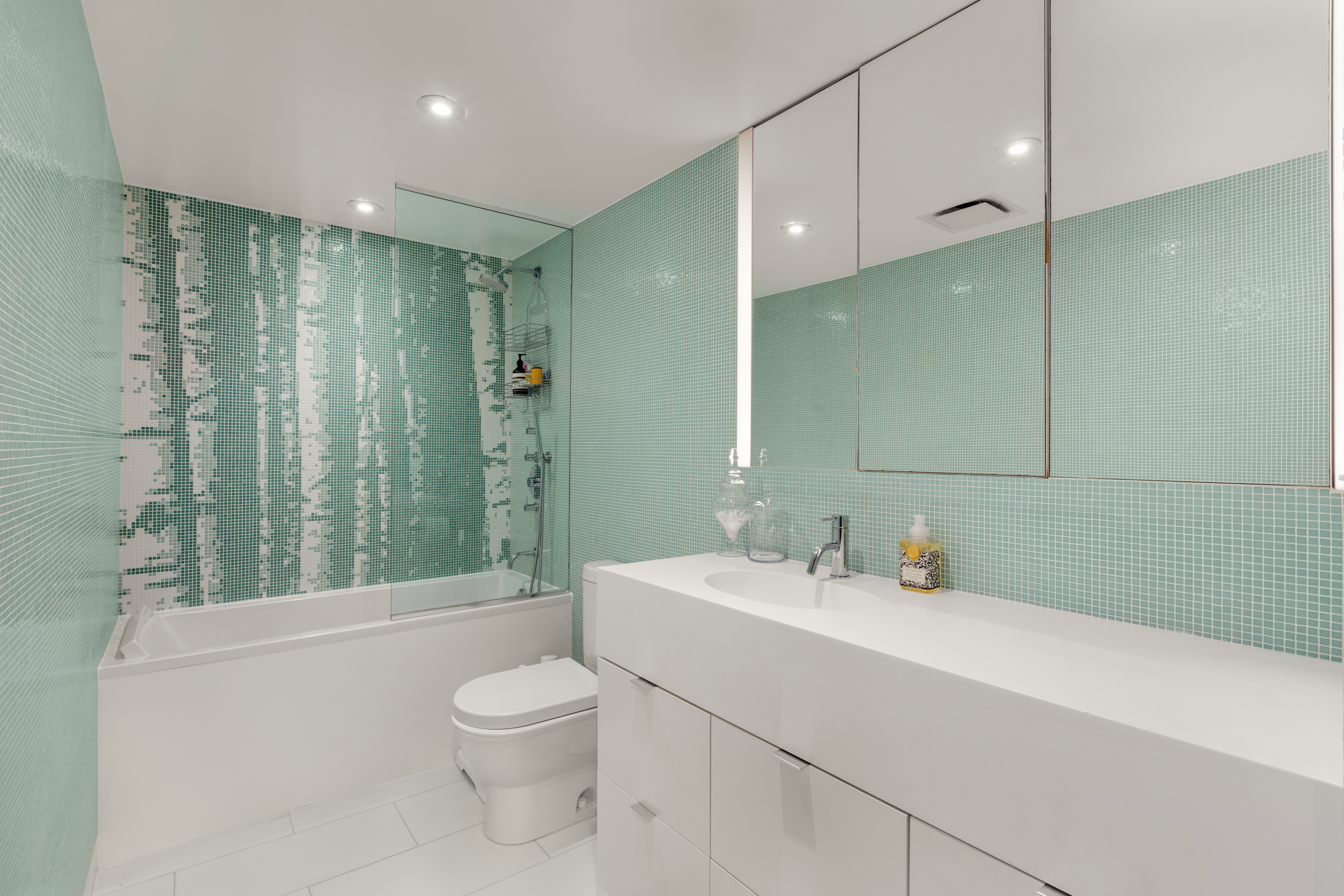 93 Reade Street, Unit 2 Manhattan, NY 10013 - Photo 7 of 9 a bathroom with a toilet a sink a mirror a shower and vanity