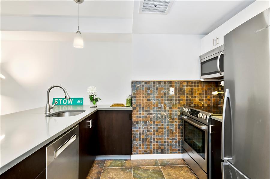189 Avenue C, Unit 2C Manhattan, NY 10009 - Photo 4 of 10 a kitchen with stainless steel appliances granite countertop a refrigerator a sink a stove and dishwasher