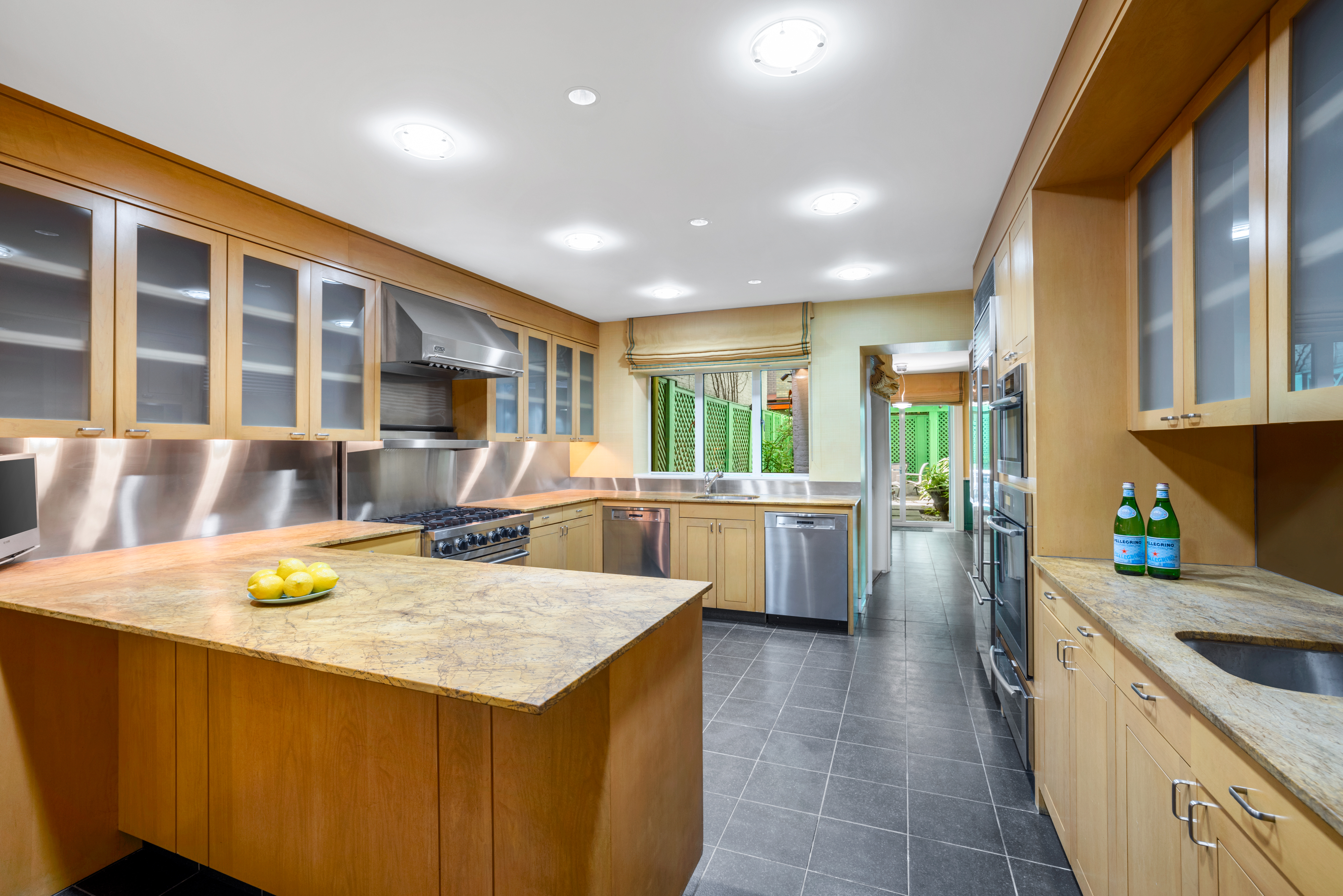 22 East 78th Street Manhattan, NY 10075 - Photo 8 of 23 a kitchen with a stove a refrigerator a sink a dining table and chairs