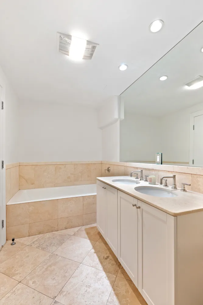 a bathroom with a tub sink and mirror