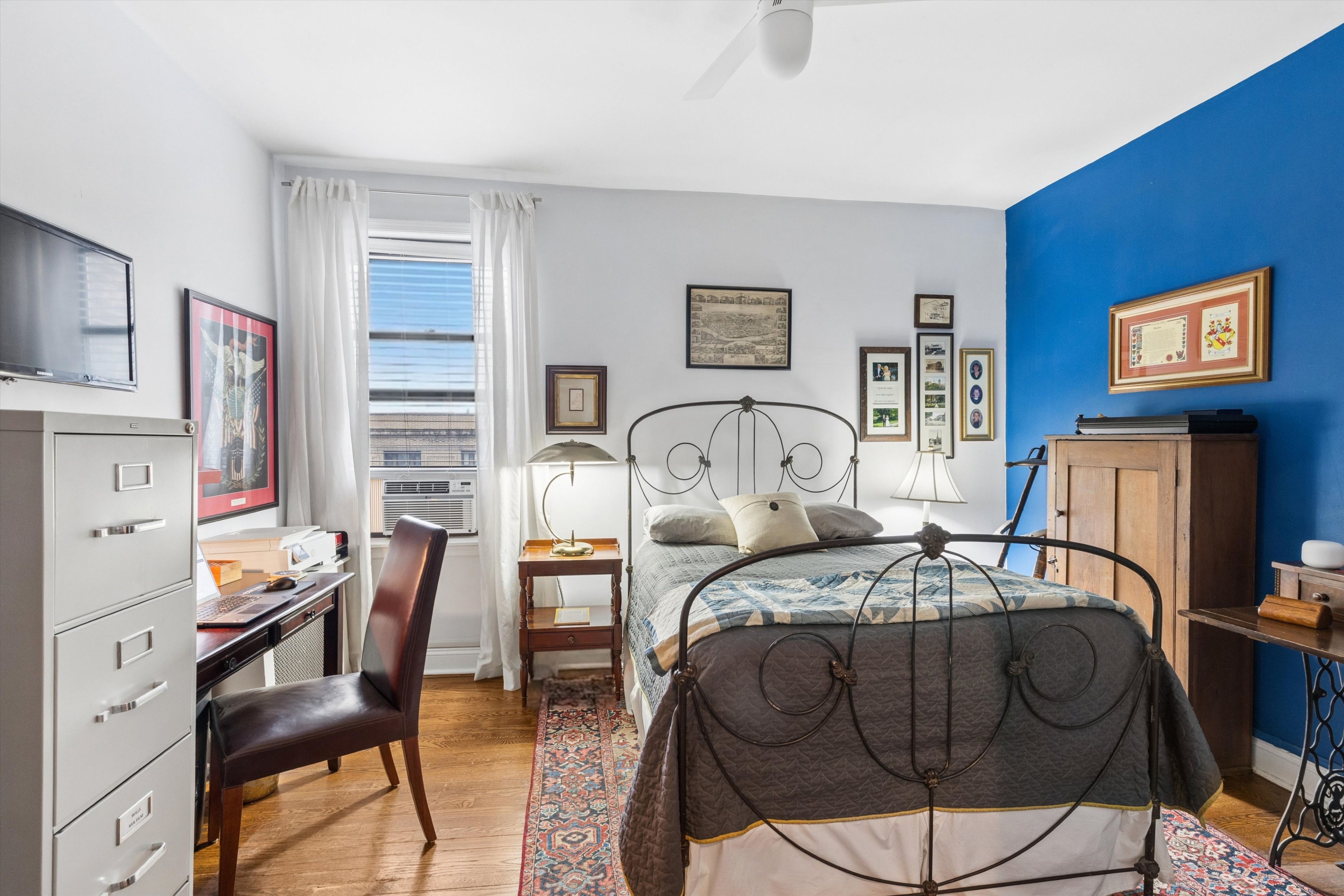 24 Bennett Avenue, Unit 62A Manhattan, NY 10033 - Photo 8 of 14 a bedroom with a bed and wooden furniture
