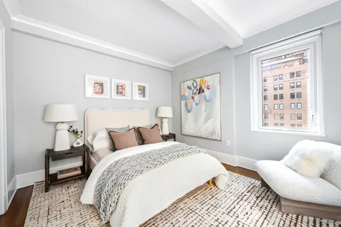 a bedroom with a bed and a couch next to a window