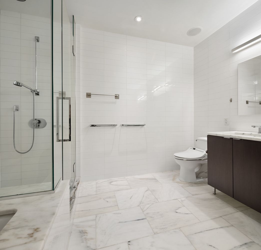 101 Warren Street, Unit 11L Manhattan, NY 10007 - Photo 12 of 26 a bathroom with a granite countertop sink a toilet and a shower