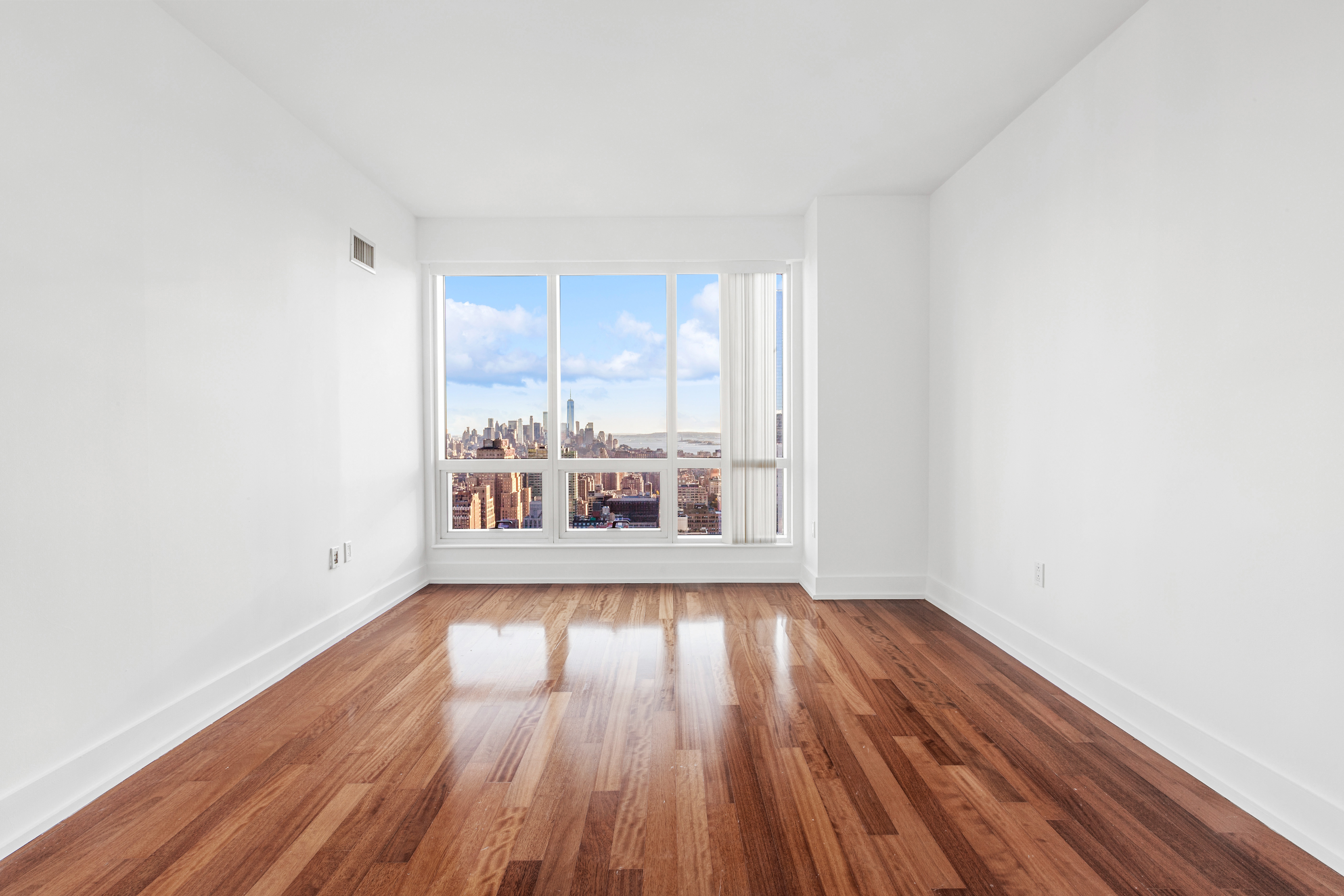 350 West 42nd Street, Unit 48E Manhattan, NY 10036 - Photo 7 of 17 an empty room with wooden floor and windows