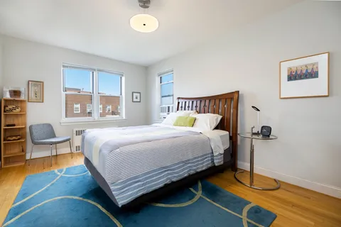a bedroom with a bed and wooden floor