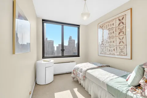 a bedroom with a bed and a large window