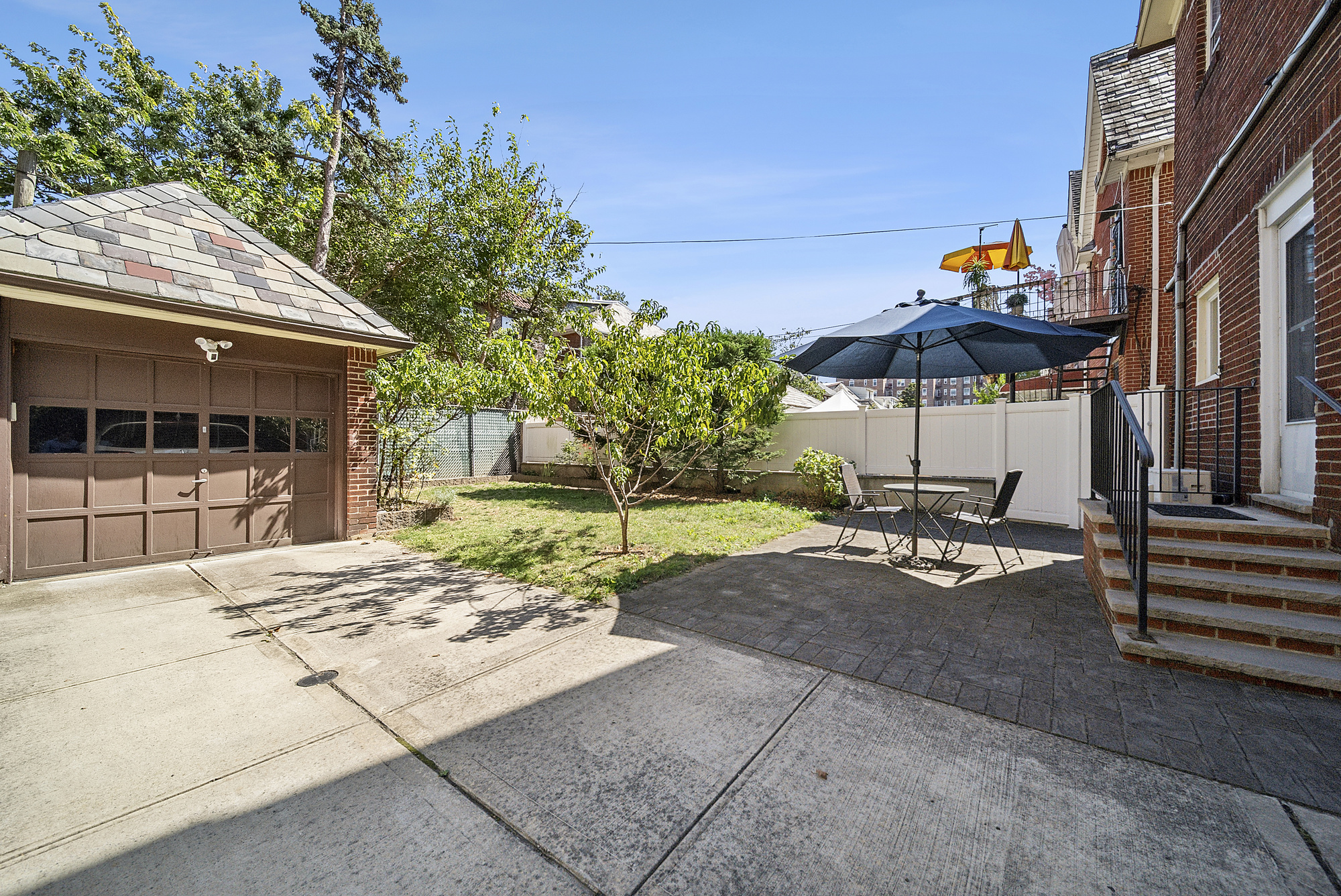 34-15 88th Street Queens, NY 11372 - Photo 13 of 15 a view of a patio with a table and chairs under an umbrella