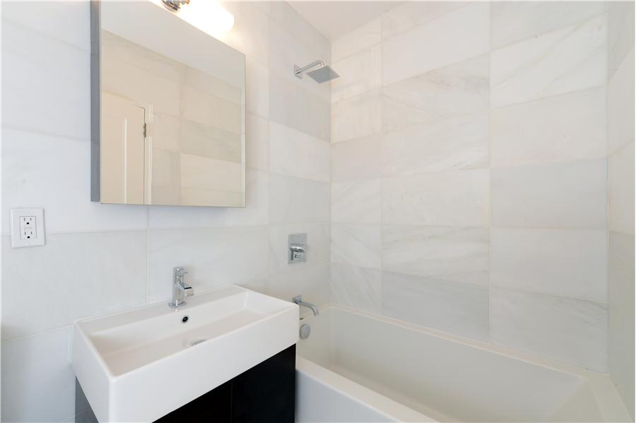 116 Central Park South, Unit 3G Manhattan, NY 10019 - Photo 4 of 8 a bathroom with a sink a shower and a mirror