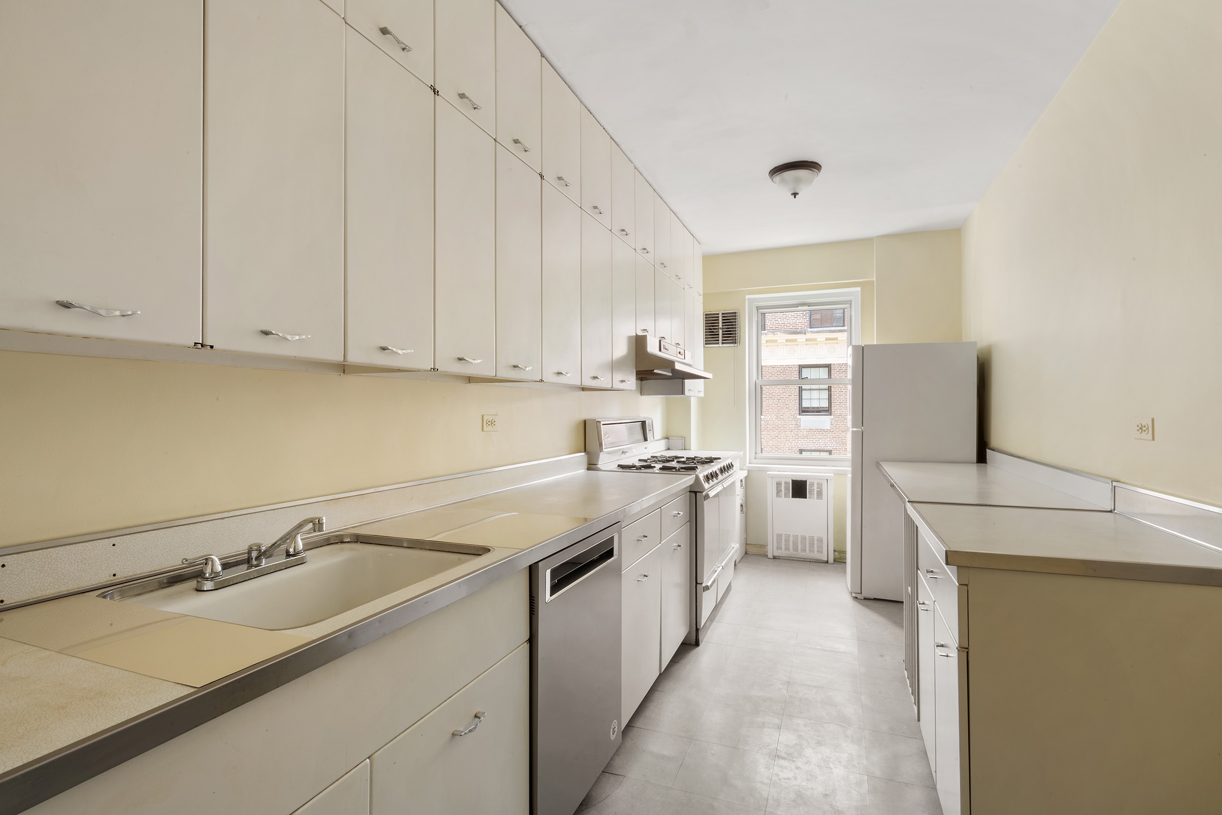 16 Sutton Place, Unit 15C Manhattan, NY 10022 - Photo 9 of 13 a kitchen with a sink stove and cabinets