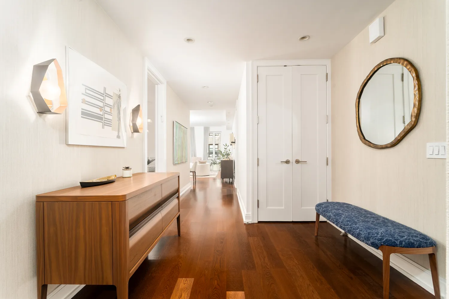a hallway with a large mirror and a dresser