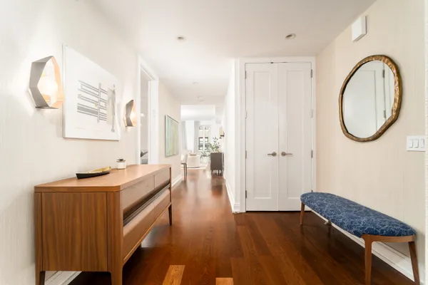 a hallway with a large mirror and a dresser