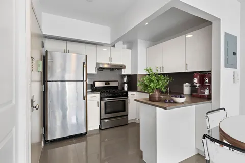a kitchen with stainless steel appliances granite countertop a refrigerator sink and stove
