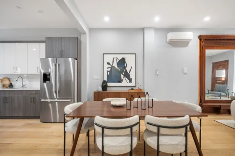 a view of a dining room with furniture and a refrigerator