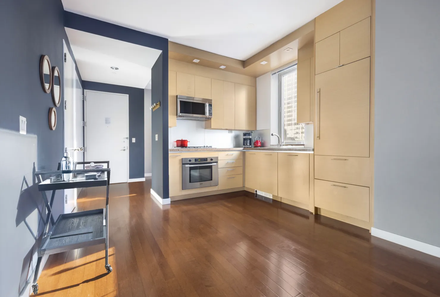 a kitchen with stainless steel appliances granite countertop a stove a sink and a refrigerator with wooden floor