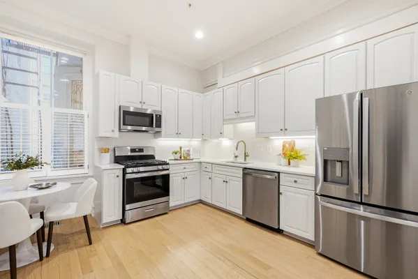 a kitchen with cabinets stainless steel appliances and window