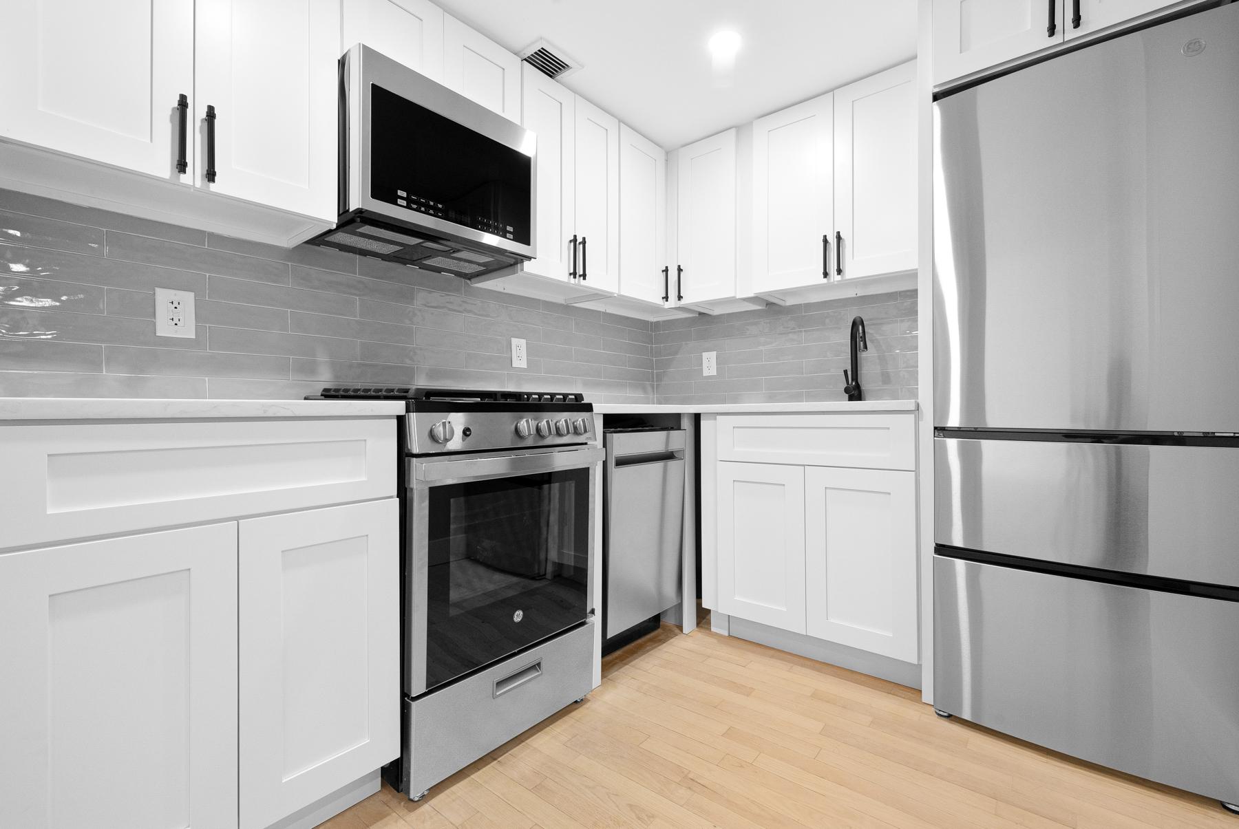 184 Thompson Street, Unit 2V Manhattan, NY 10012 - Photo 3 of 8 a kitchen with a stove and a microwave