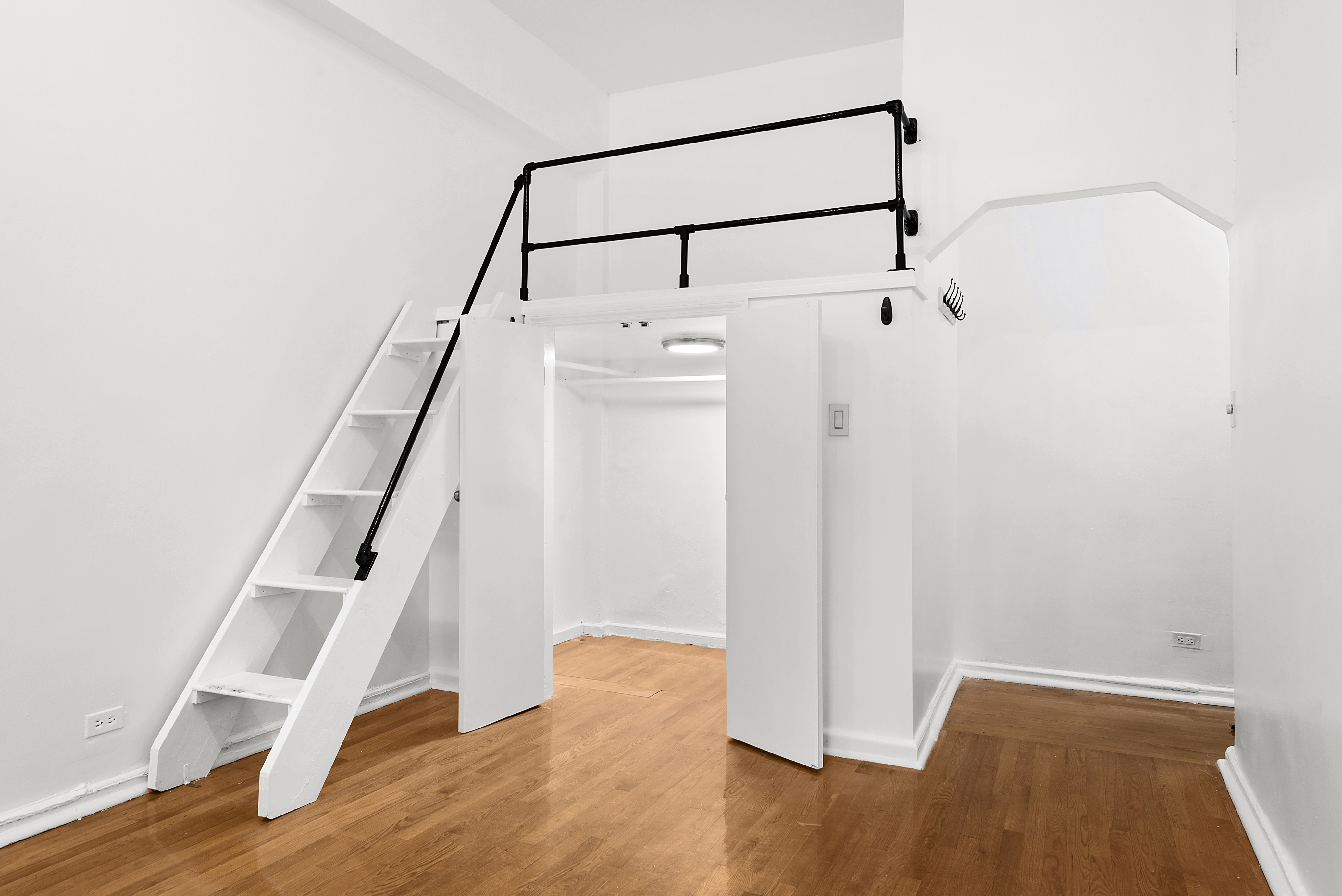 159-34 Riverside Drive West, Unit 1F90 Manhattan, NY 10032 - Photo 2 of 14 a view of an empty room with wooden floor and stairs