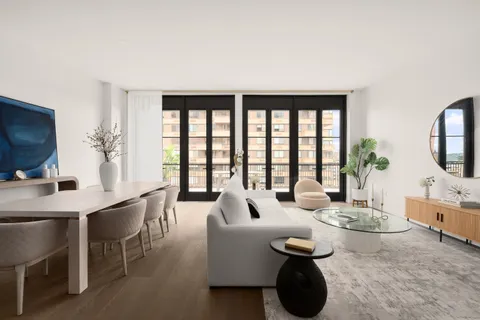 a living room with furniture a large window and a flat screen tv