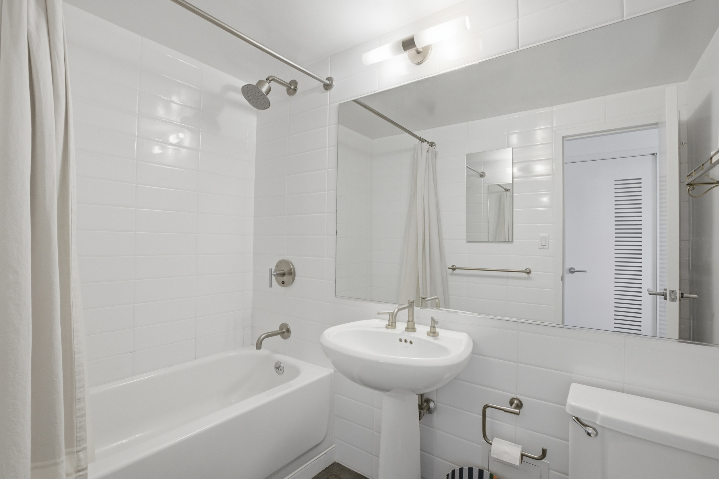 305 2nd Avenue, Unit 521 Manhattan, NY 10003 - Photo 13 of 20 a bathroom with a sink a toilet and shower