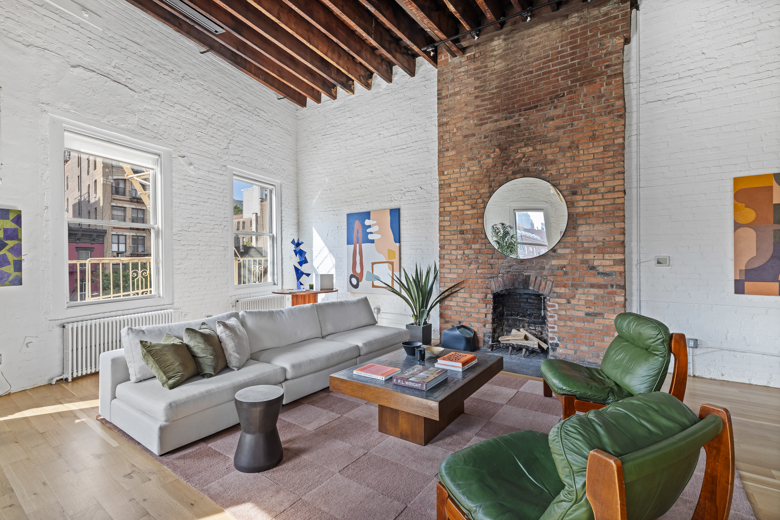 325 Bowery, Unit PH Manhattan, NY 10003 - Photo 5 of 17 a living room with furniture a rug potted plant and a window