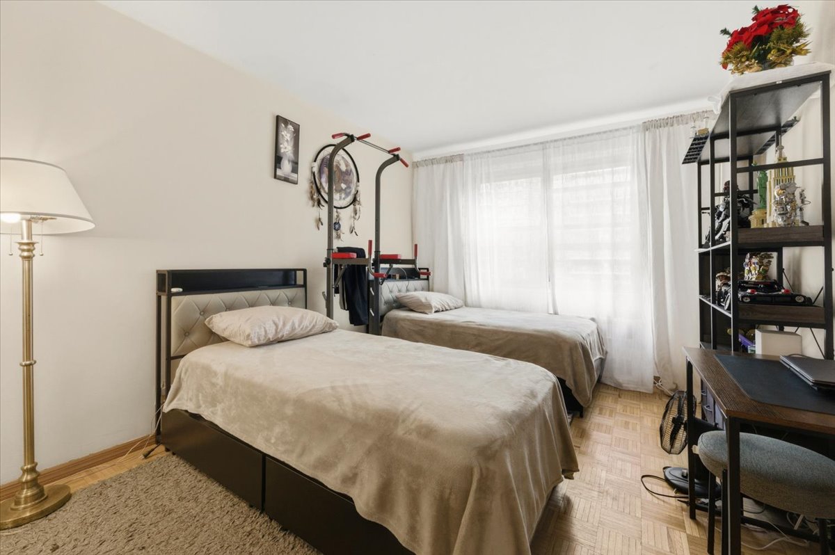 448 Neptune Avenue, Unit 14J Brooklyn, NY 11224 - Photo 7 of 21 a bedroom with a bed and a book shelf