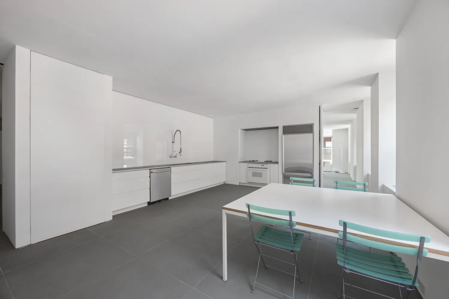 a kitchen with white cabinets and wooden floor