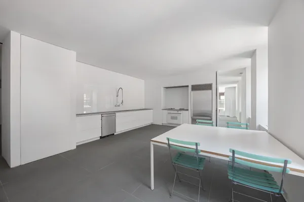 a kitchen with white cabinets and wooden floor