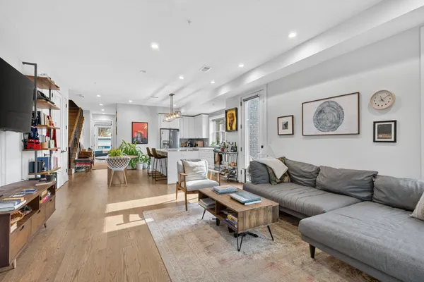 a living room with furniture a flat screen tv and a window