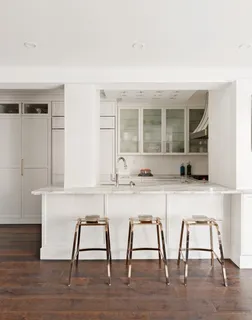 a white kitchen with a sink cabinets and wooden floor