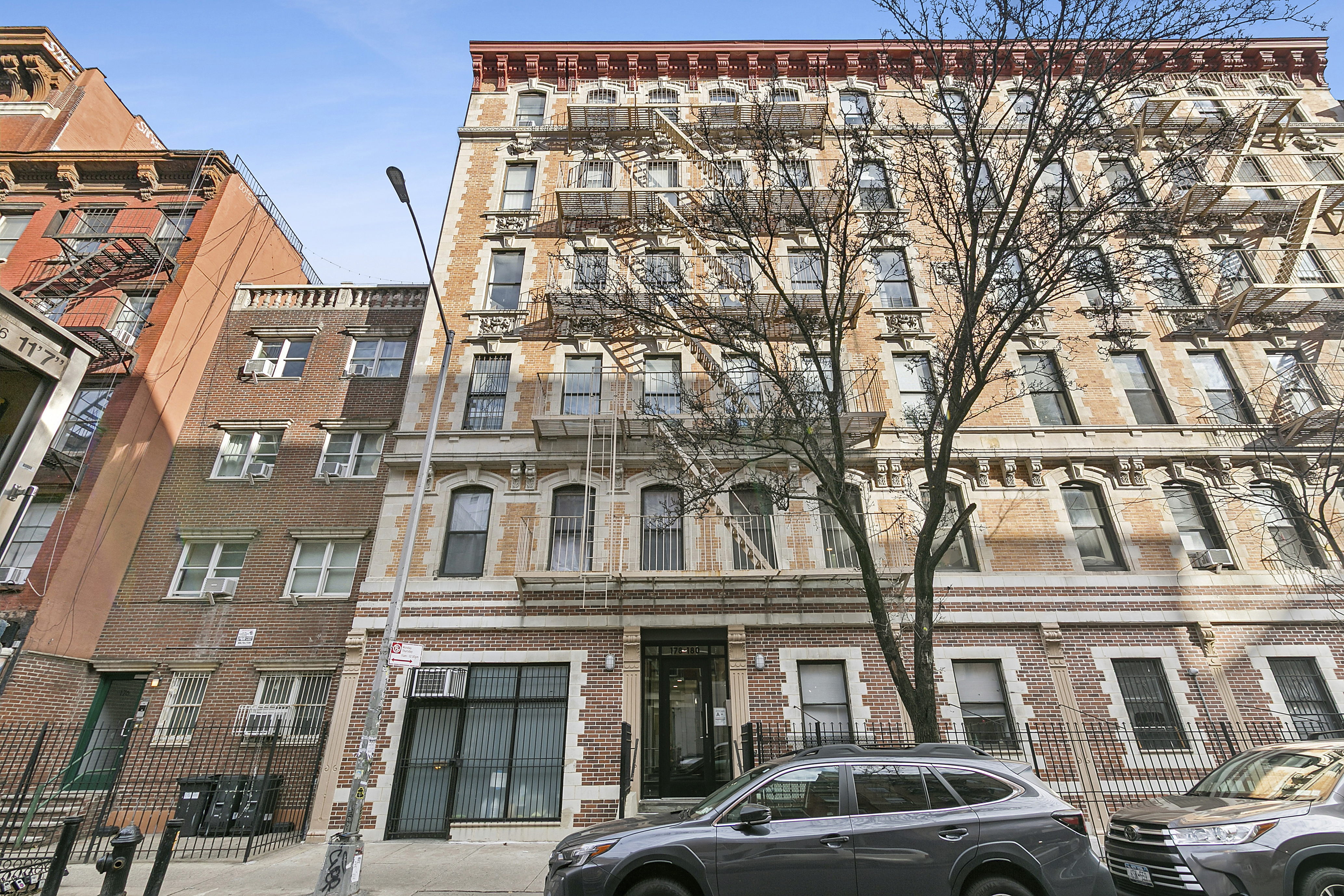 178 East 2nd Street, Unit 1B Manhattan, NY 10009 - Photo 10 of 11 a front view of a building with lot of cars and trees