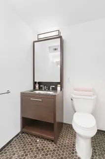 a bathroom with a toilet and a mirror