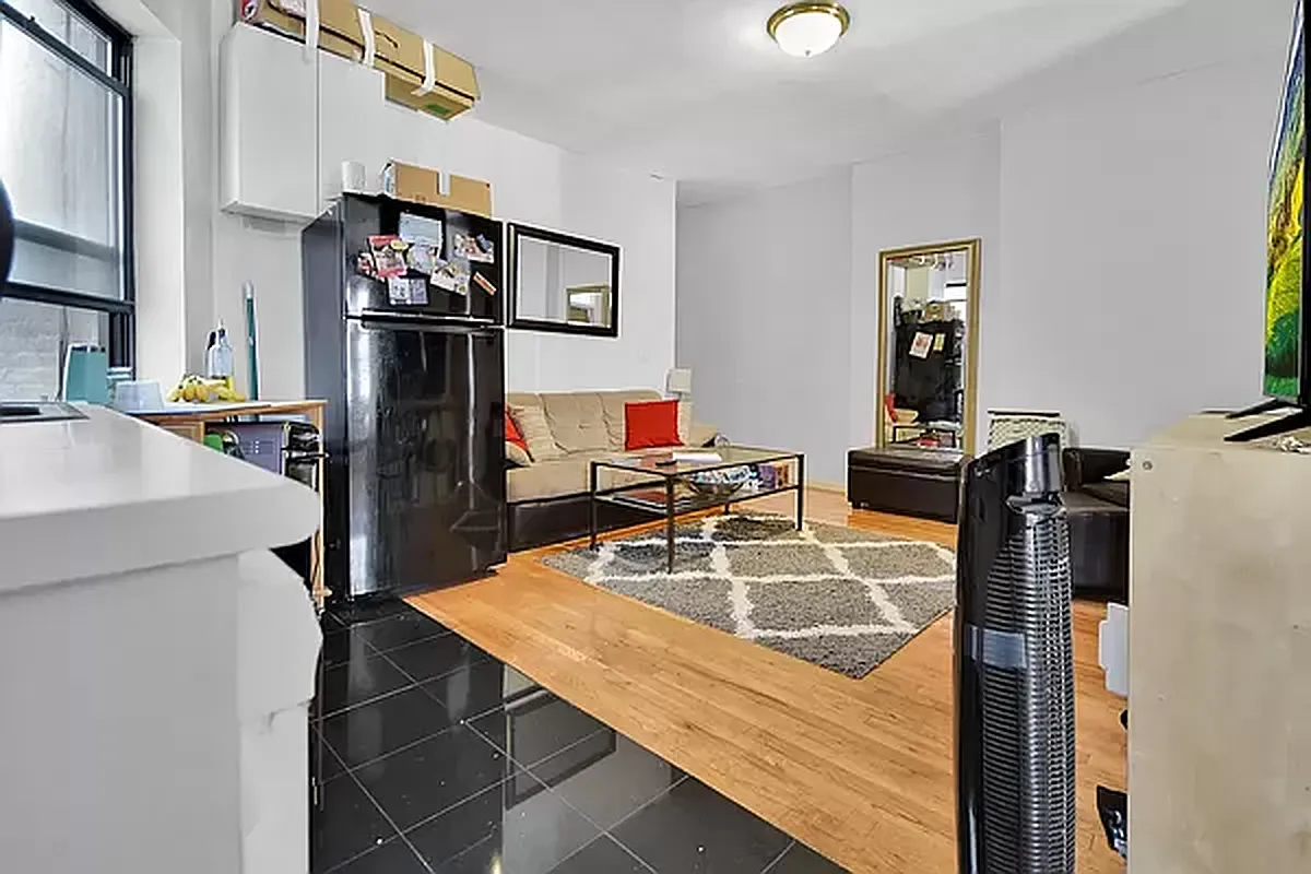 416 East 71st Street, Unit 17 Manhattan, NY 10021 - Photo 6 of 8 a kitchen with a refrigerator a stove and a dining table with wooden floor