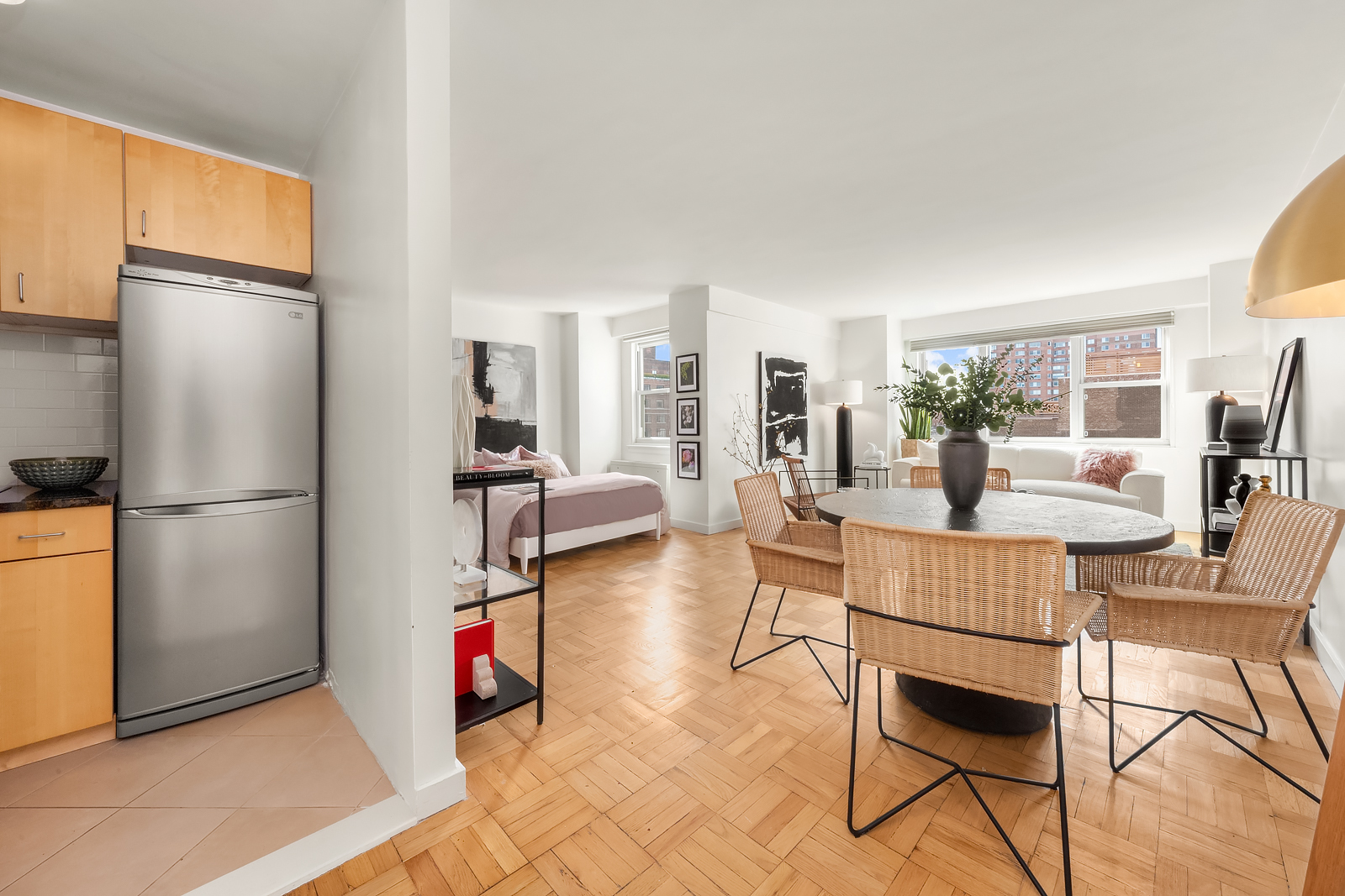 101 West 12th Street, Unit 10F Manhattan, NY 10011 - Photo 1 of 12 a living room with furniture a dining table and a refrigerator
