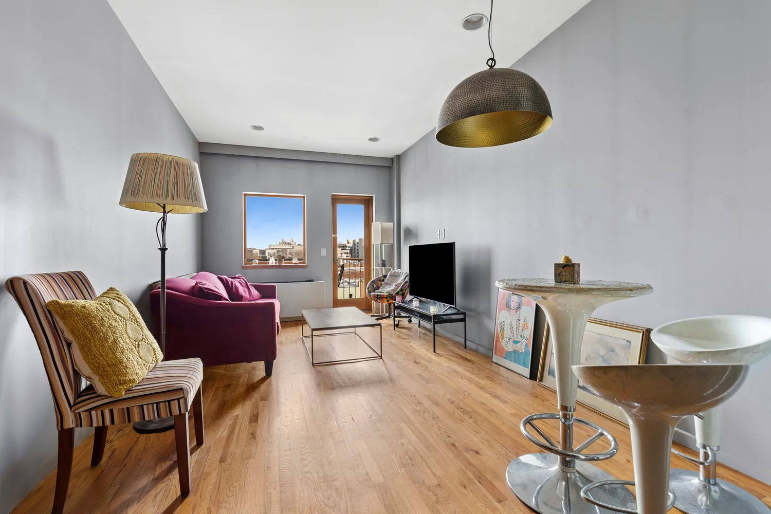 a living room with furniture a desk and chair with wooden floor