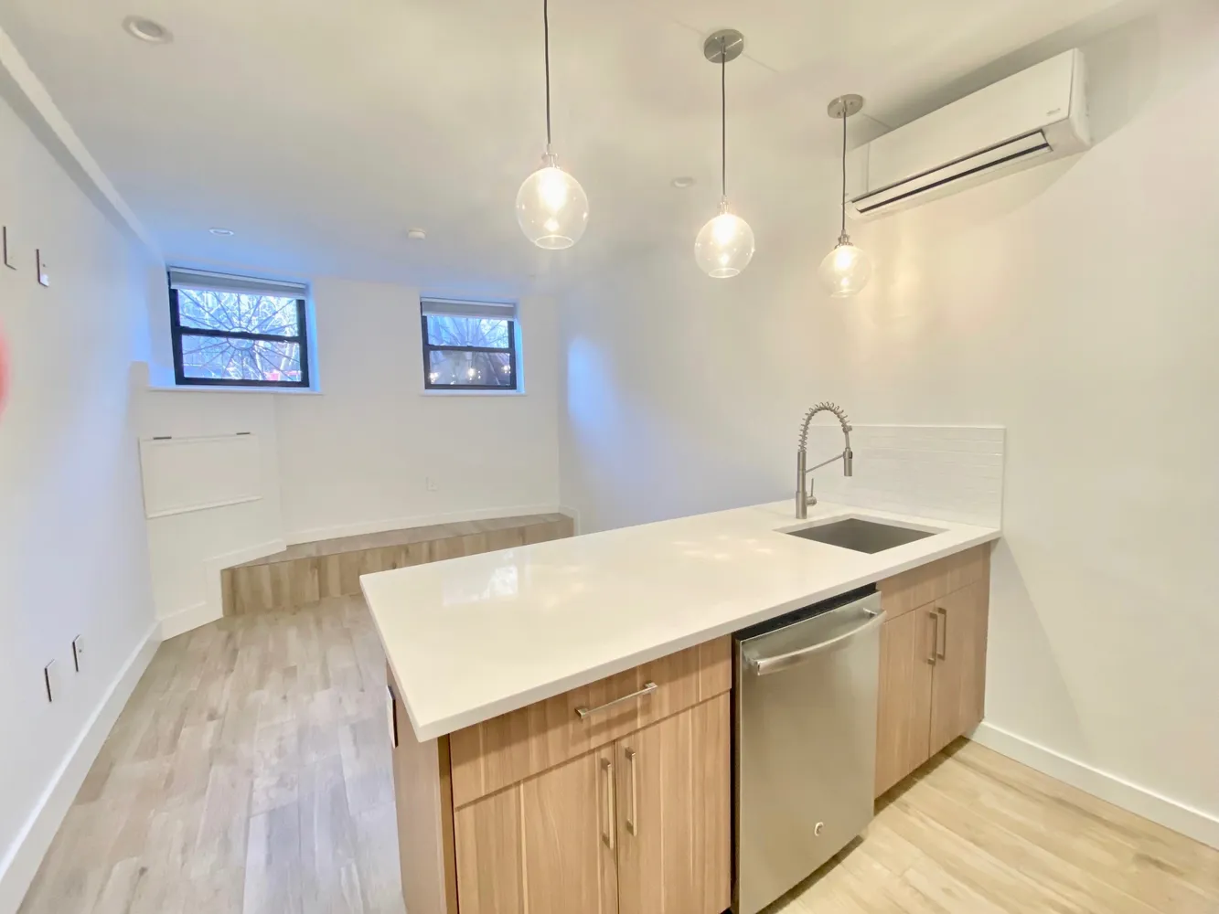 a kitchen with a sink and a wooden floor
